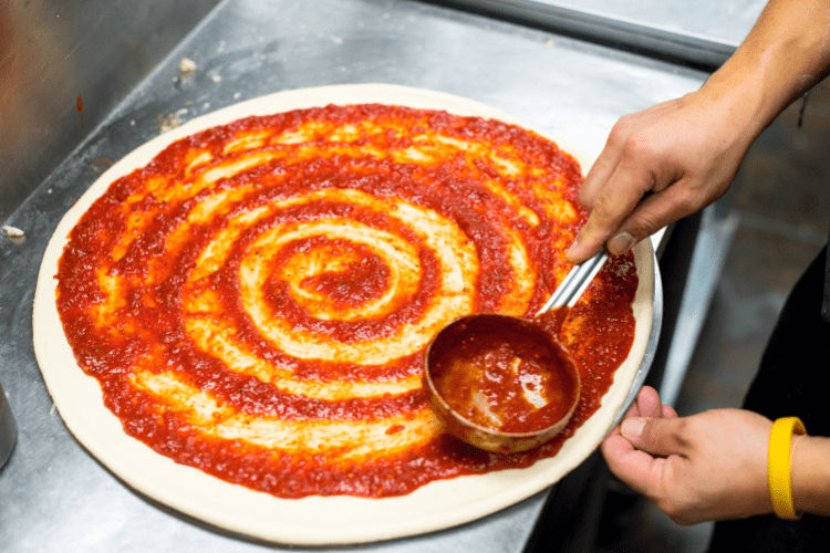 Spreading Pizza Sauce On The Dough